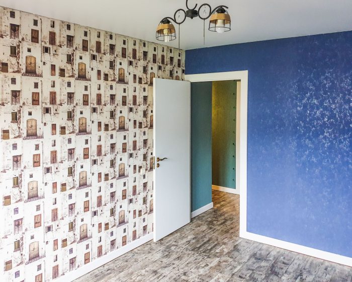 Zimmer mit gemustertem Tapetenakzent und strukturierter Wandfarbe
